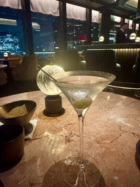 マルティニグラスのカクテル。窓の外はすでに夜