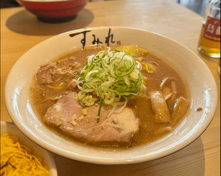すみれの味噌ラーメン。表面をラードの膜が覆い、白髪ねぎとチャーシューがのっている