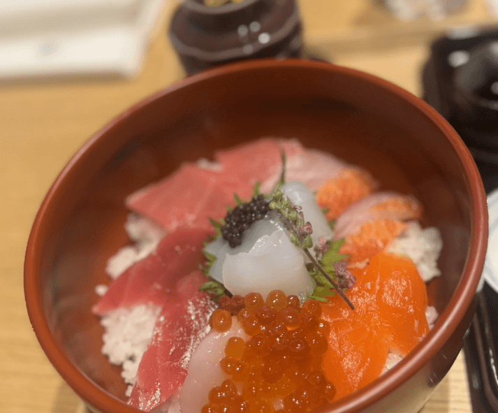 朱塗りの器に盛った海鮮丼。まぐろ、サーモン、いくらがのっている