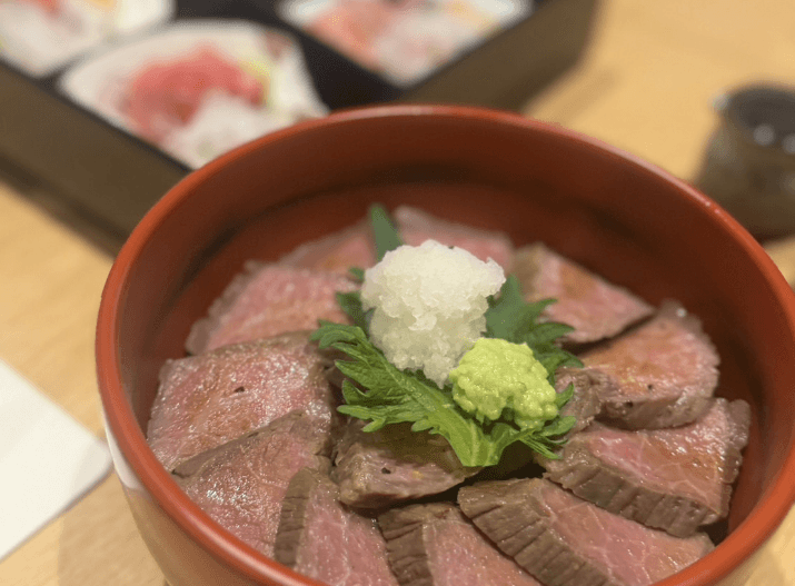 朱塗りの器に盛ったローストビーフ丼。大根おろしとわさびが添えられている
