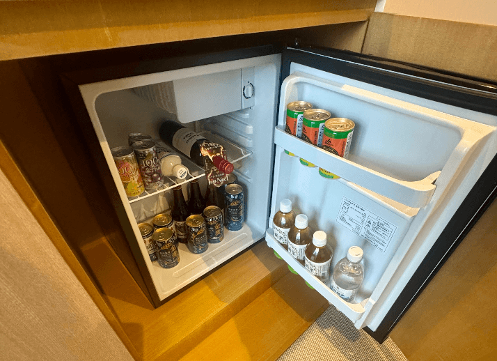 客室の冷蔵庫を開けたところ。缶や瓶の飲み物がぎっしり詰まっている