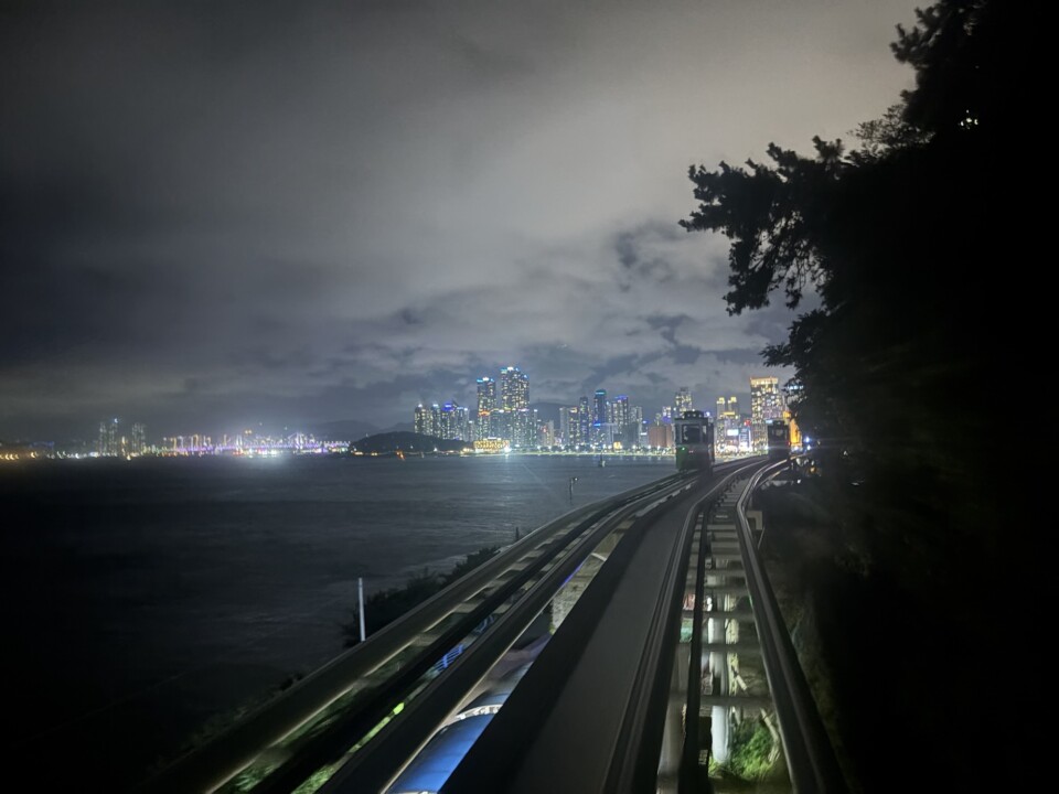 超高層ビルの足元で夜風に吹かれる