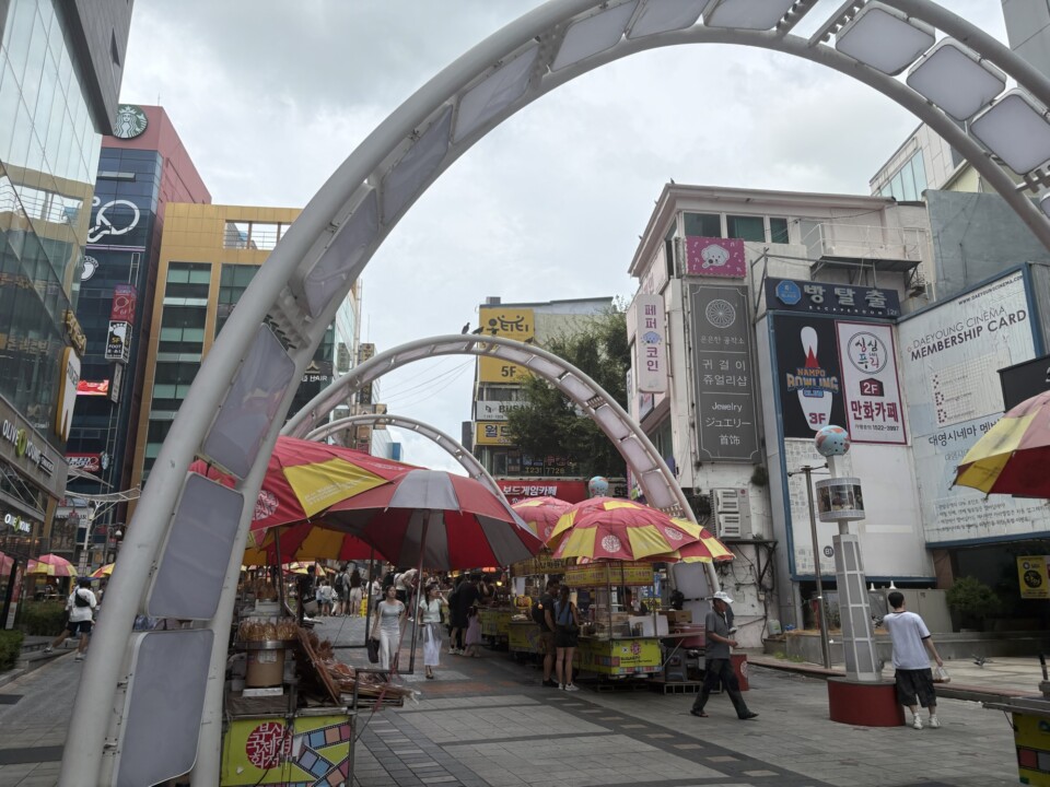 BIFF広場の入口アーチと赤い屋台のパラソルが並ぶ通り（釜山・南浦洞）