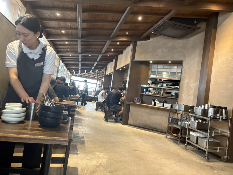 韓屋風の梁とオープンキッチンが印象的なオムヨンベク店内。朝から席が埋まっていく