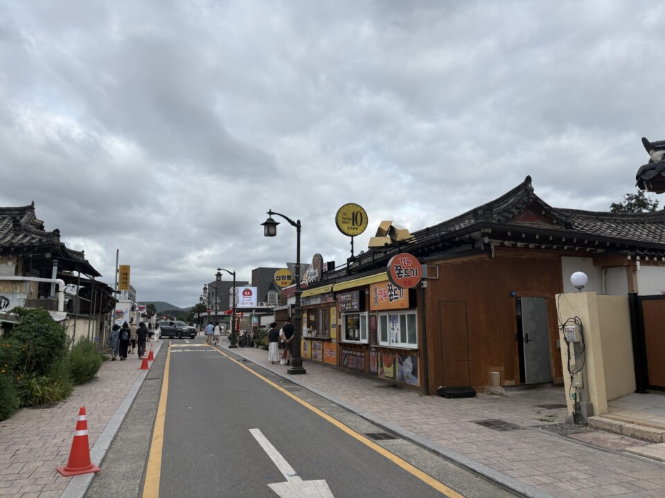 皇理団キルの通りに掲げられた10ウォン硬貨の看板。韓屋の軒先に十円パンの店が並ぶ