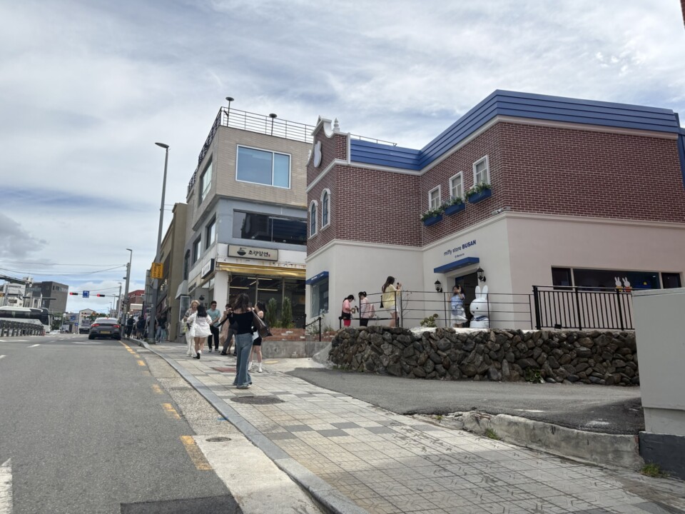 レンガ造りのミッフィーストア釜山店の外観。入口前の白いミッフィー像に人が集まる