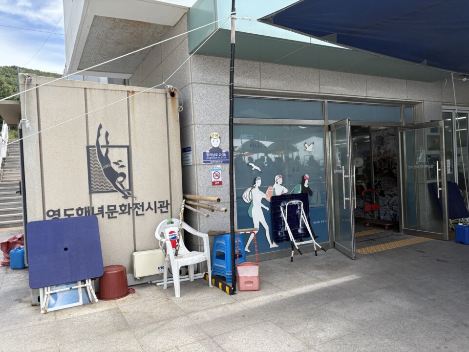 影島海女文化展示館の入口。海に潜る海女のシンボルマークが描かれている