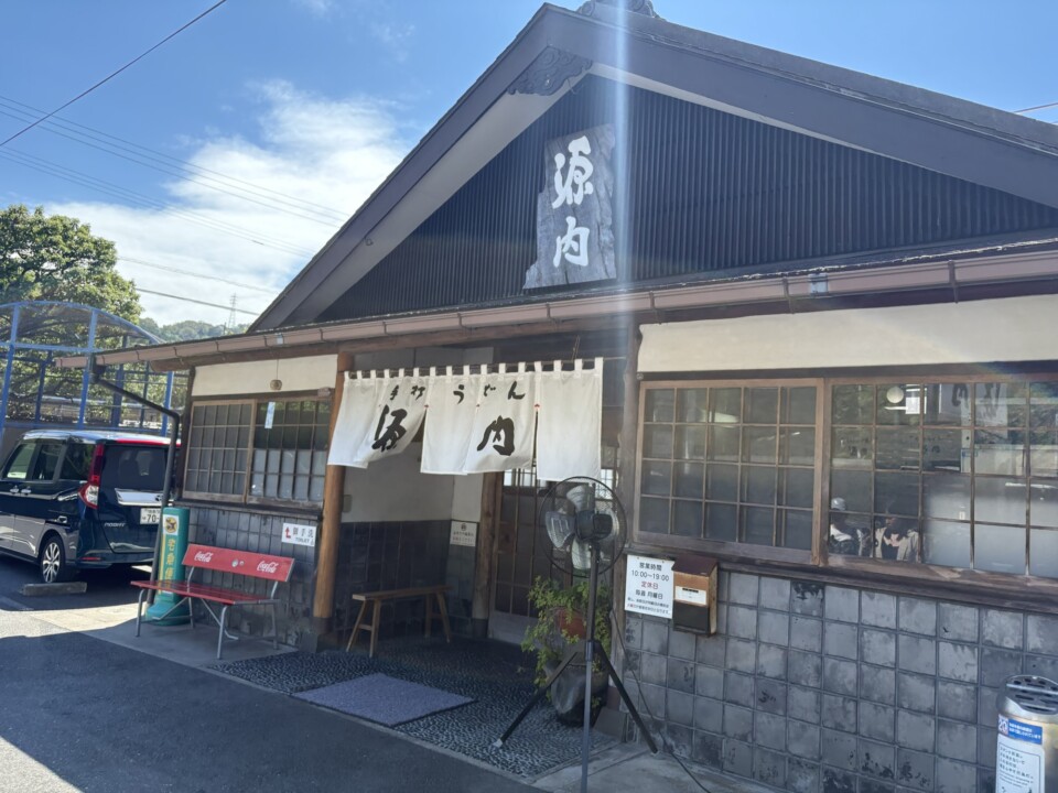 「源内」の看板と暖簾がかかった、手打うどん源内の外観