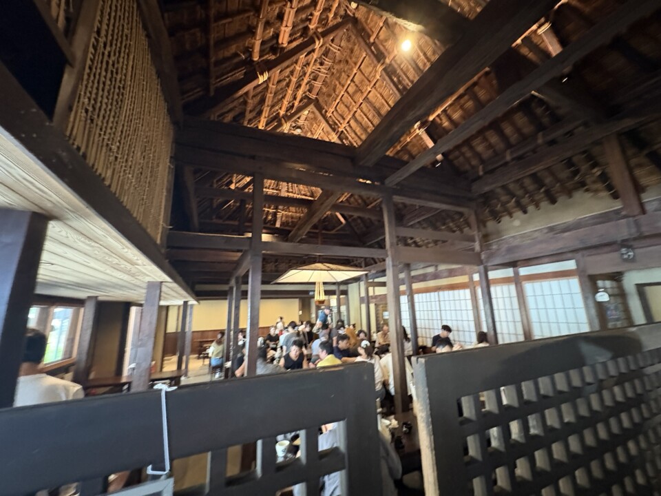 太い梁と高い天井の店内。大勢の客で席が埋まっている