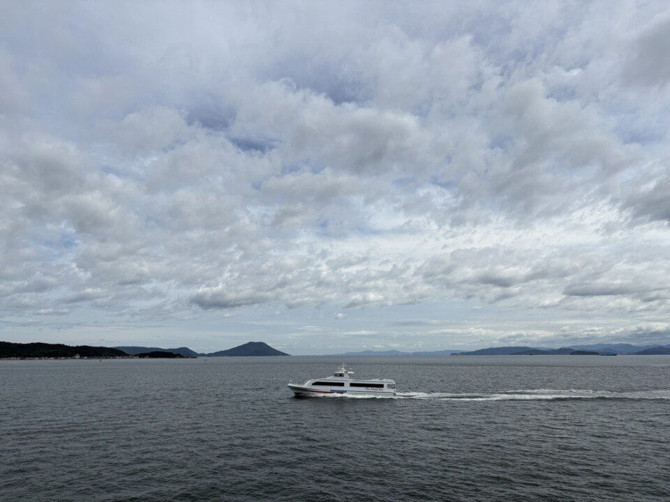 瀬戸内海を走る白い高速船と、遠くに連なる島々