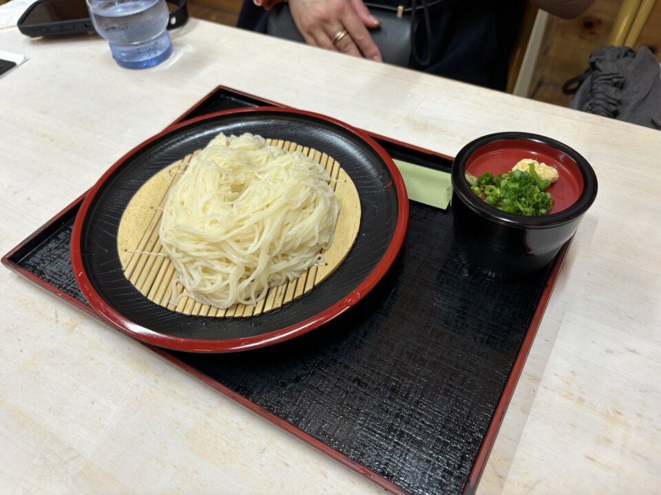 竹すだれにのった白い生そうめんと、つゆ、薬味