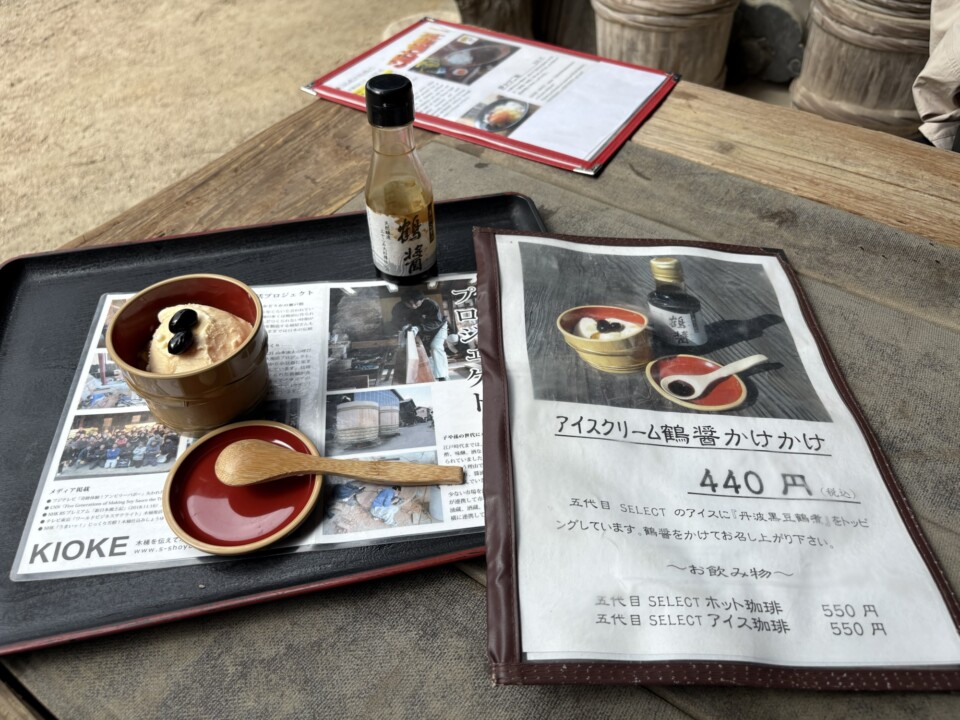 木のテーブルに置かれたアイスクリームと、鶴醤の小瓶、「アイスクリーム鶴醤かけ 440円」のメニュー