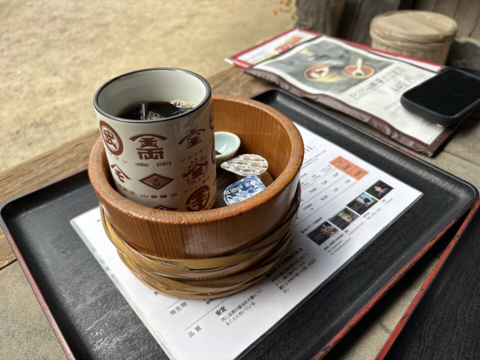 木桶を小さくしたような器に入ったアイスコーヒー